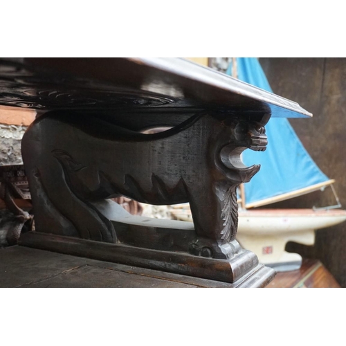 1088 - A carved oak monks bench, with hinged box seat, 106.5cm wide.