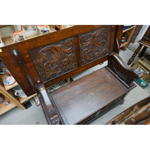 1088 - A carved oak monks bench, with hinged box seat, 106.5cm wide.