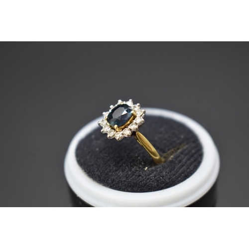 73 - An 18ct gold sapphire and diamond cluster ring, size E.