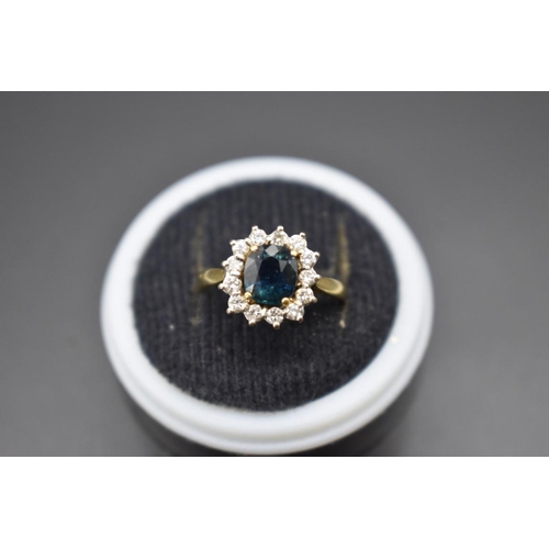 73 - An 18ct gold sapphire and diamond cluster ring, size E.