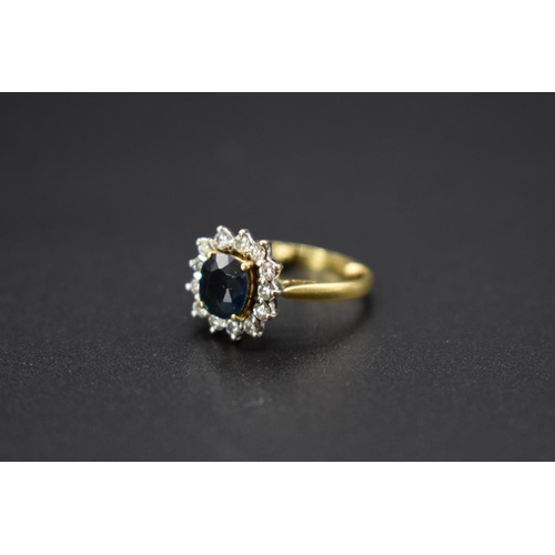 73 - An 18ct gold sapphire and diamond cluster ring, size E.