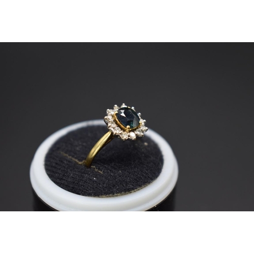 73 - An 18ct gold sapphire and diamond cluster ring, size E.