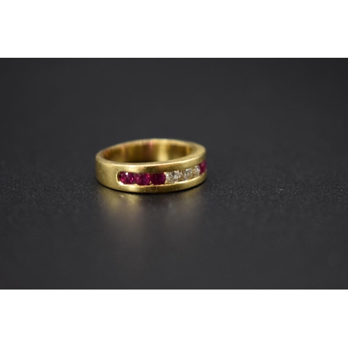 74 - A yellow metal diamond and ruby half eternity ring, stamped .750, size I 1/2.