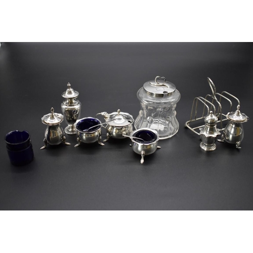 63 - A quantity of silver, to include: a five piece cruet set; and a silver lidded glass preserve jar.... 