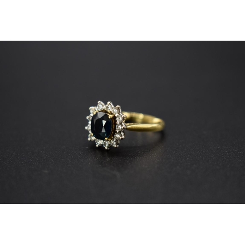 73 - An 18ct gold sapphire and diamond cluster ring, size E.