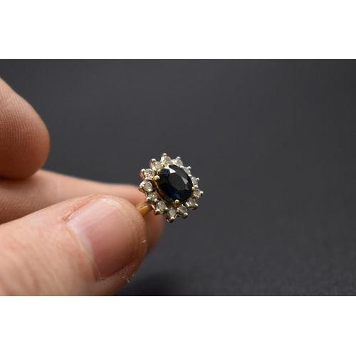 73 - An 18ct gold sapphire and diamond cluster ring, size E.