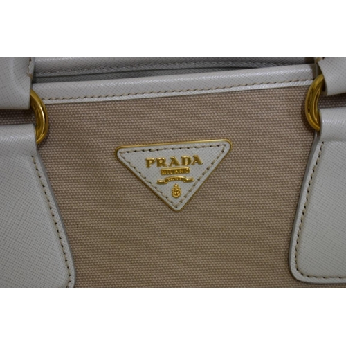 1810 - Prada: a large beige canvas and leather handbag with gilt hardware and detachable webbing shoulder s... 