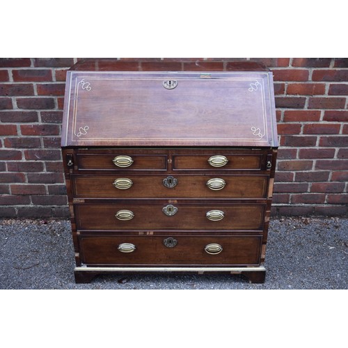 1086 - An unusual George III mahogany and brass inlaid bureau, in the manner of John Channon, the fall encl... 