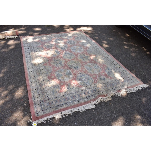 1102 - A Persian style carpet, having floral and geometric borders on a pink ground, 266 x 190cm.... 