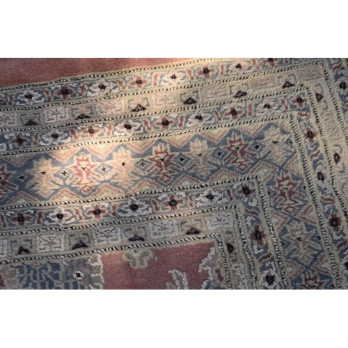 1102 - A Persian style carpet, having floral and geometric borders on a pink ground, 266 x 190cm.... 