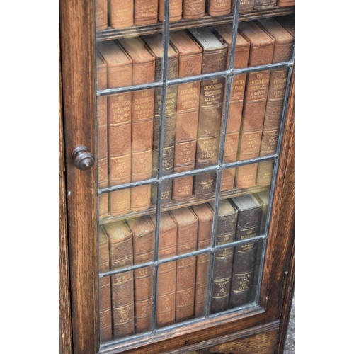 1077 - A 1930s oak slim bookcase, containing a quantity of 1911 Encyclopaedia Britannica books, 36.5cm wide... 