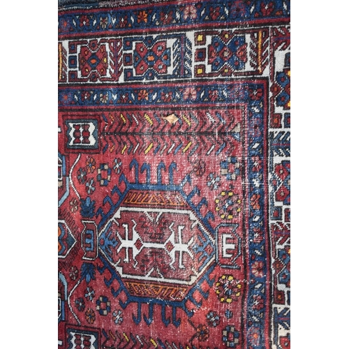 1102 - A Tribal rug, having three central medallions with geometric borders, 175 x 122cm.
