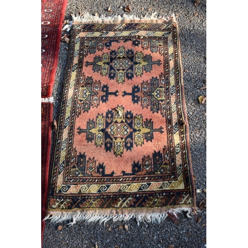 1105 - Two small Bokhara rugs; together with another small rug having geometric decoration.... 