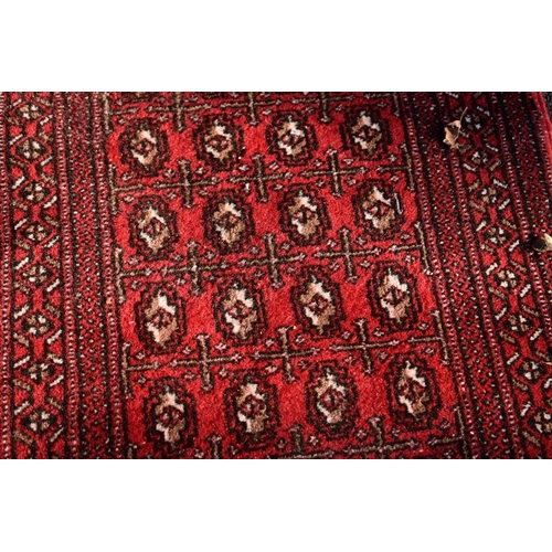 1106 - A Bokhara runner on a red ground, 262 x 56cm.