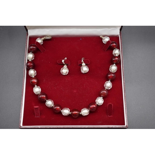 239 - A contemporary chunky foiled red and clear glass bead necklace and matching earrings, the necklace 4... 