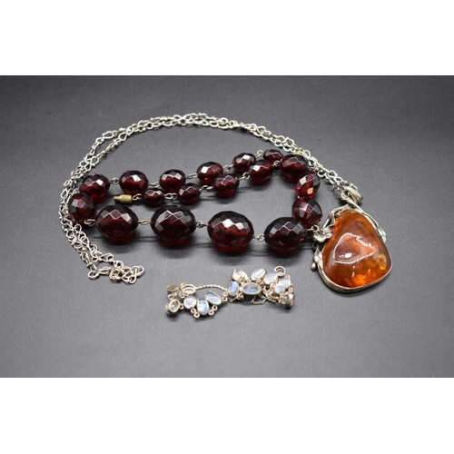 223 - A graduated and faceted cherry amber bead necklace, 43cm, 49g; together with an amber pendant, on ch... 