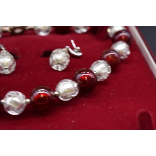 239 - A contemporary chunky foiled red and clear glass bead necklace and matching earrings, the necklace 4... 