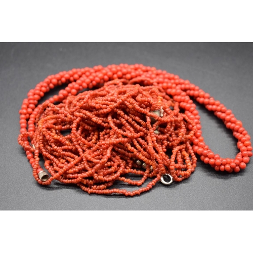 243 - A coral tassel torsade necklace, having nineteen strands with plated clasp, 50cm; together with anot... 