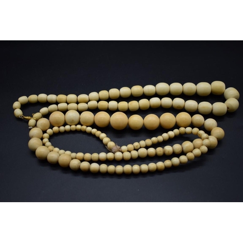 245 - Two early 20th century ivory graduated bead necklaces, 88 and 58cm.