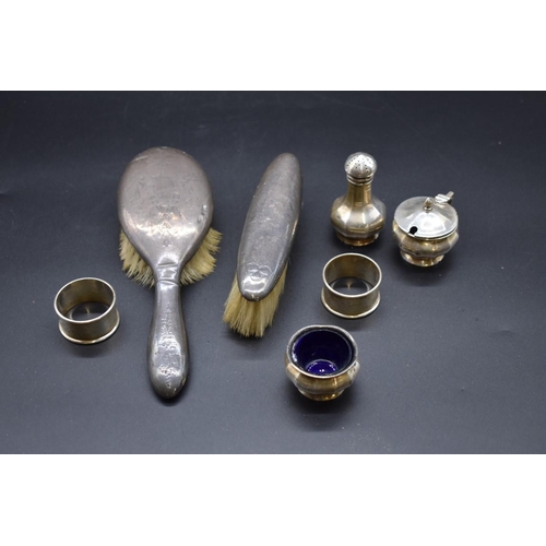 499 - A silver three piece condiment set; together with two silver napkin rings; and two silver mounted ha... 