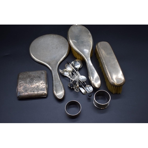 499Q - A silver three piece brush set; together with a silver cigarette case; two silver napkin rings; two ... 