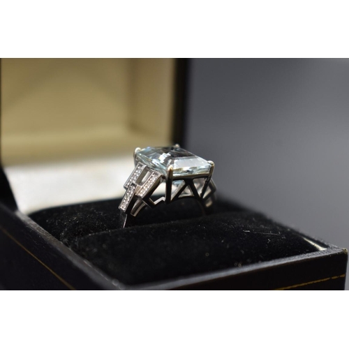 61 - A white metal aquamarine ring, 4.1ct, with 14 small diamonds set to shoulders, stamped 14k, size N, ... 