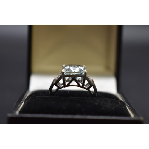 61 - A white metal aquamarine ring, 4.1ct, with 14 small diamonds set to shoulders, stamped 14k, size N, ... 