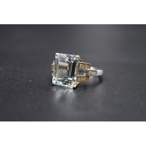 61 - A white metal aquamarine ring, 4.1ct, with 14 small diamonds set to shoulders, stamped 14k, size N, ... 