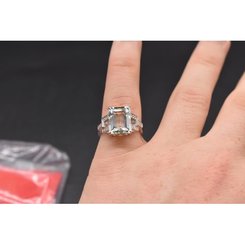 61 - A white metal aquamarine ring, 4.1ct, with 14 small diamonds set to shoulders, stamped 14k, size N, ... 