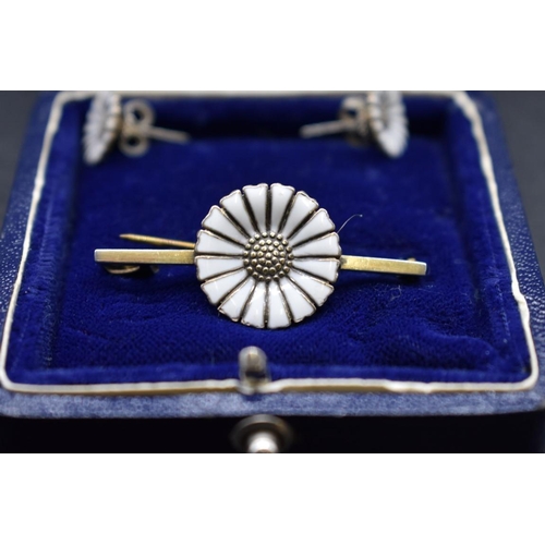 63 - A Danish sterling silver gilt and enamel daisy bar brooch and matching ear studs, by Anton Michelsen... 