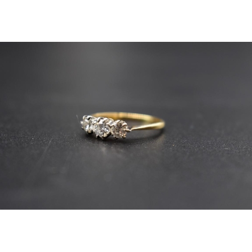 76 - A yellow metal diamond three stone ring, size L.