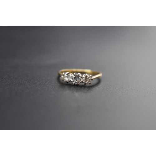 76 - A yellow metal diamond three stone ring, size L.