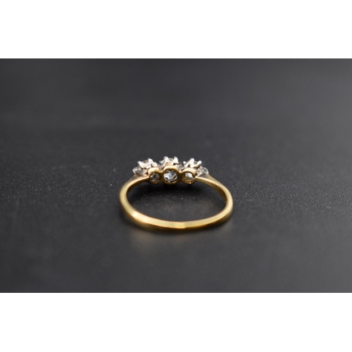 76 - A yellow metal diamond three stone ring, size L.