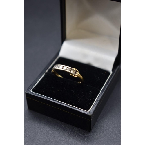 82 - An 18ct gold channel set diamond seven stone half eternity ring, size R 1/2, 3g.