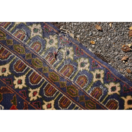 1105a - A Persian rug,&nbsp;central field decorated with two urns and flowers, 200 x 113cm.