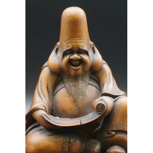 1290 - A good Japanese carved wood figure of a seated immortal, possibly Fukurokuju, Meiji, holding a scrol... 