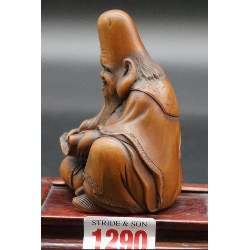 1290 - A good Japanese carved wood figure of a seated immortal, possibly Fukurokuju, Meiji, holding a scrol... 