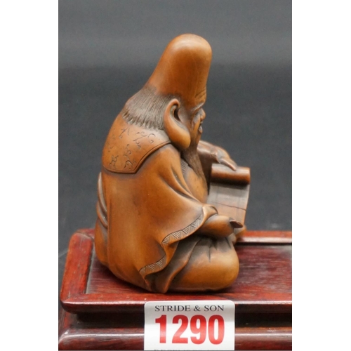 1290 - A good Japanese carved wood figure of a seated immortal, possibly Fukurokuju, Meiji, holding a scrol... 