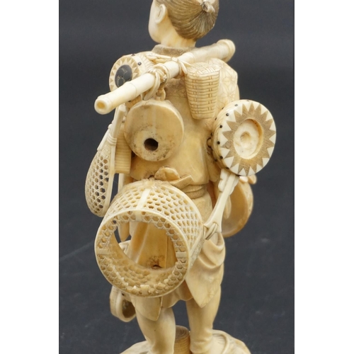 1298 - A Japanese carved ivory okimono, Meiji, depicting a basket seller, seal mark on inset tablet, 18cm h... 