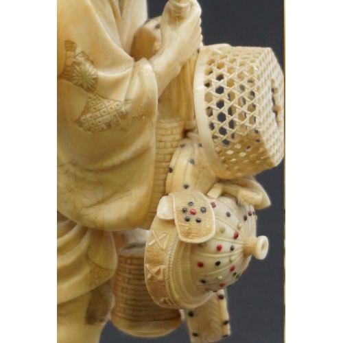 1298 - A Japanese carved ivory okimono, Meiji, depicting a basket seller, seal mark on inset tablet, 18cm h... 