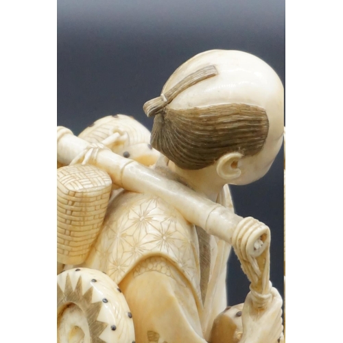 1298 - A Japanese carved ivory okimono, Meiji, depicting a basket seller, seal mark on inset tablet, 18cm h... 