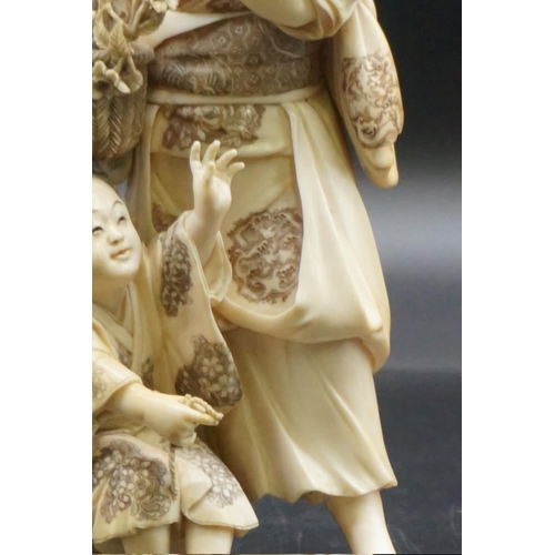 1301 - A large Japanese carved ivory okimono figure group, Meiji, depicting a mother and child with a baske... 