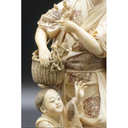 1301 - A large Japanese carved ivory okimono figure group, Meiji, depicting a mother and child with a baske... 