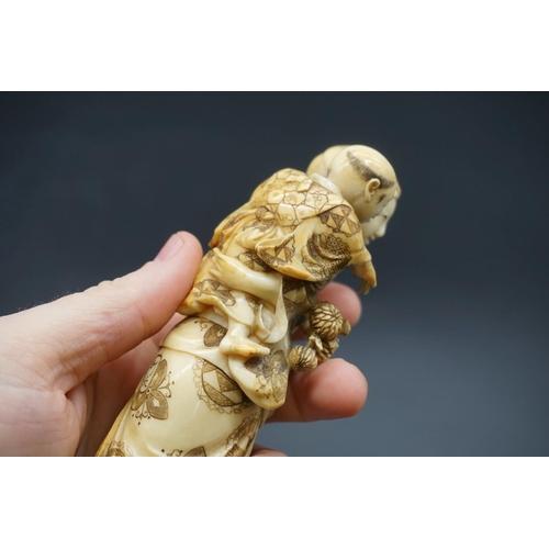 1303 - A good Japanese carved ivory okimono figure group, 19th century, depicting a standing mother, with a... 