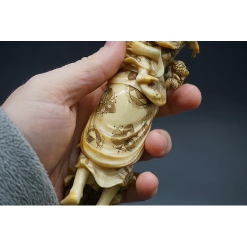 1303 - A good Japanese carved ivory okimono figure group, 19th century, depicting a standing mother, with a... 