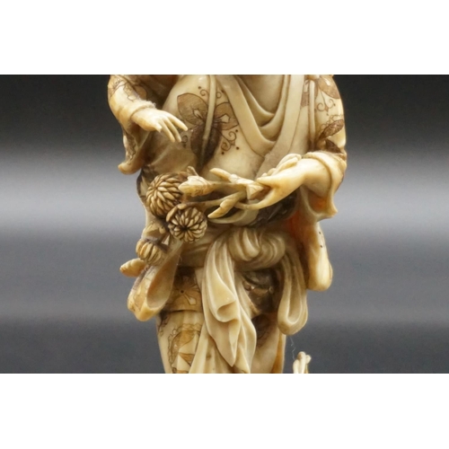 1303 - A good Japanese carved ivory okimono figure group, 19th century, depicting a standing mother, with a... 