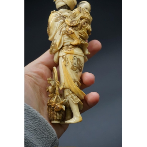 1303 - A good Japanese carved ivory okimono figure group, 19th century, depicting a standing mother, with a... 