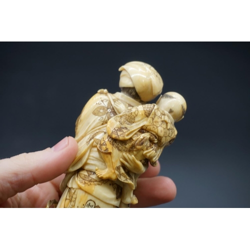 1303 - A good Japanese carved ivory okimono figure group, 19th century, depicting a standing mother, with a... 