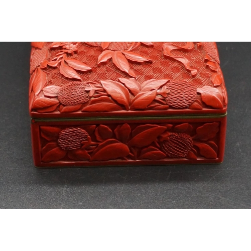 1307 - A Chinese cinnabar lacquer casket, late Qing, finely carved with a basket of fruit to the hinged cov... 