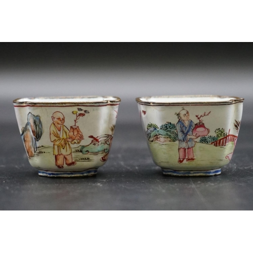 1312 - A pair of canton enamel tea bowls, Kangxi, each painted with figures in a continuous landscape, 3.3c... 